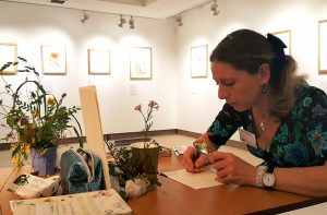 Lizzie demonstrating botanical illustration at her exhibition